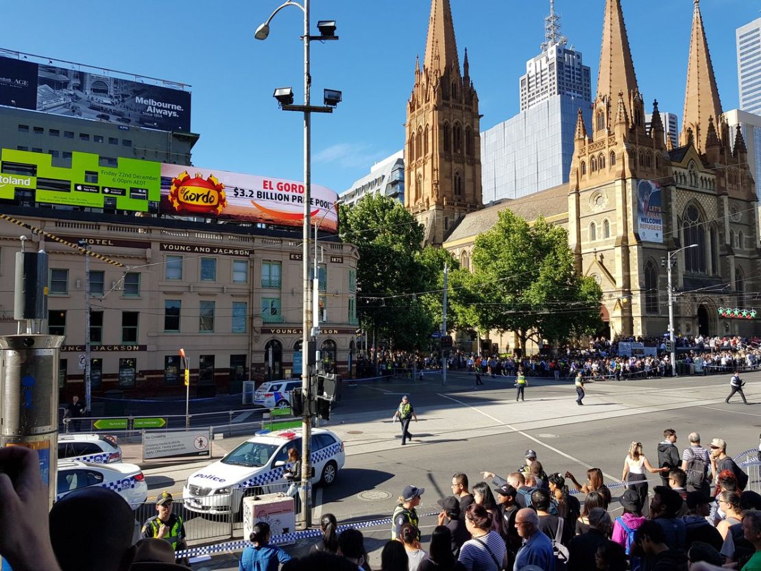 Police fence off bystanders at the pedestrian crossing next to Flinders Street Station in Melbourne, on Thursday.