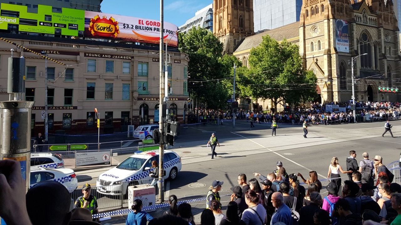Police fence off bystanders at the pedestrian crossing next to Flinders Street Station in Melbourne, on Thursday.
