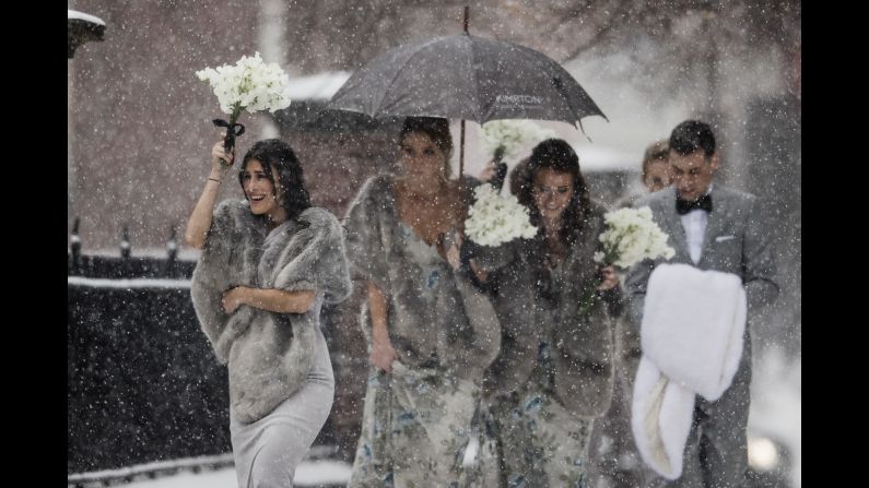 A bridal party makes its way through a snowstorm in Philadelphia on Friday, December 15.