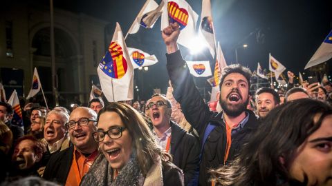 Supporters wave flags and banners at the Ciutadans party headquarters as they celebrate the results of the election Thursday.