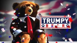 Trump plus bear equals Trumpy Bear...bizarro gift of the holiday season. Jeanne Moos cuddles one.    Trumpy Bear   It's the perfect Christmas gift for...we're not sure who. You may or may not have ever seen the TV infomercial for Trumpy Bear and, even if you saw it, you probably couldn't tell if it was real. That's the joy of this story...the hilarious commercial hawking the plush stuffed bear with Donald Trump's hair and a flag that looks like a cape when you pull it out of the zipper pouch on his back. Only two easy payments of $19.95!   "And no, this is not a joke",  writes the designer to CNN..."I felt it was time to name an American fearless grizzly bear after our new Commander and Chief." The designer teamed up with a company that specializes in making TV infomercials and this is a classic. We have obtained our very own Trumpy Bear, who unfortunately can't tweet because he has no fingers. But what he lacks in digits, he more than makes up for with the red tie and unruly hair. Just stop everything and watch the commercial. Comes complete with a Certificate of Authenticity, which we play off against Trump demanding to see a certain birth certificate.