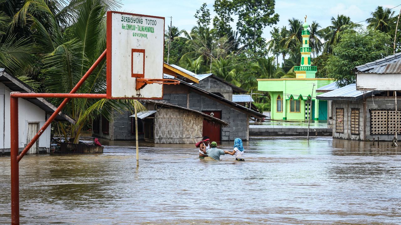 Evacuees walk through floodwaters to a safer place in Kabacan on the island of Mindanao on December 23. 