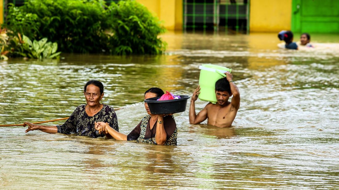 Residents maneuver floodwaters on Mindanao on December 23. 