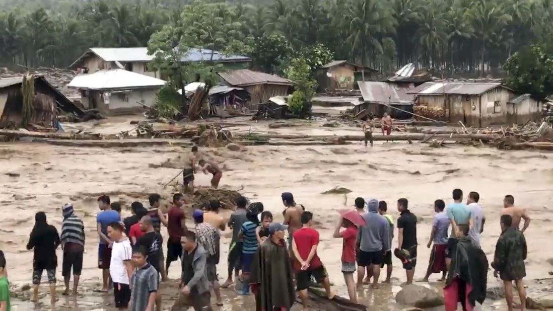 Villagers cross raging floodwaters December 22 in Lanao del Norte province in the southern Philippines in this photo made from video by Aclimah Disumala. 