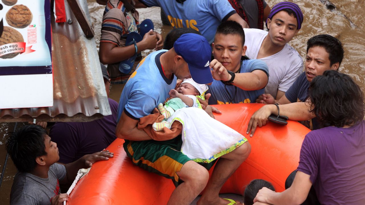 Police officers evacuate a baby Friday in Cagayan de Oro after Tropical Storm Tembin hit.