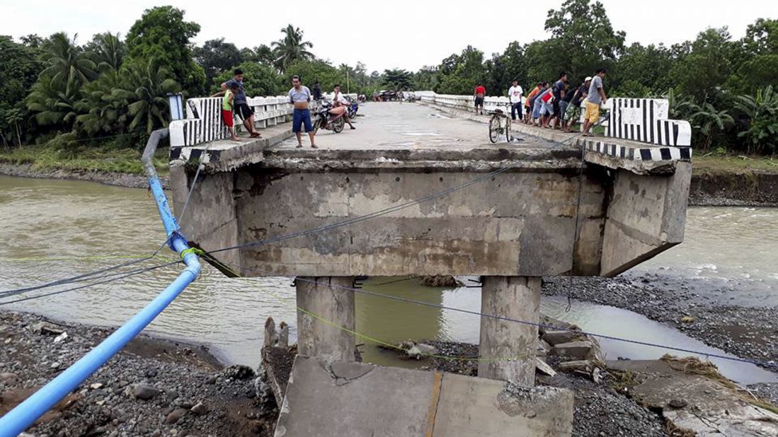 People gather on a bridge which was damaged by flooding Sunday, December 24, after <a href="http://www.cnn.com/2017/12/23/asia/philippines-tropical-storm-tembin/index.html" target="_blank">Tropical Storm Tembin</a> dumped heavy rains on the area. 