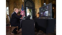 President Donald Trump points to the video screen during a Christmas Eve video teleconference with members of the mIlitary at his Mar-a-Lago estate in Palm Beach, Fla., Sunday, Dec. 24, 2017. (AP Photo/Carolyn Kaster)