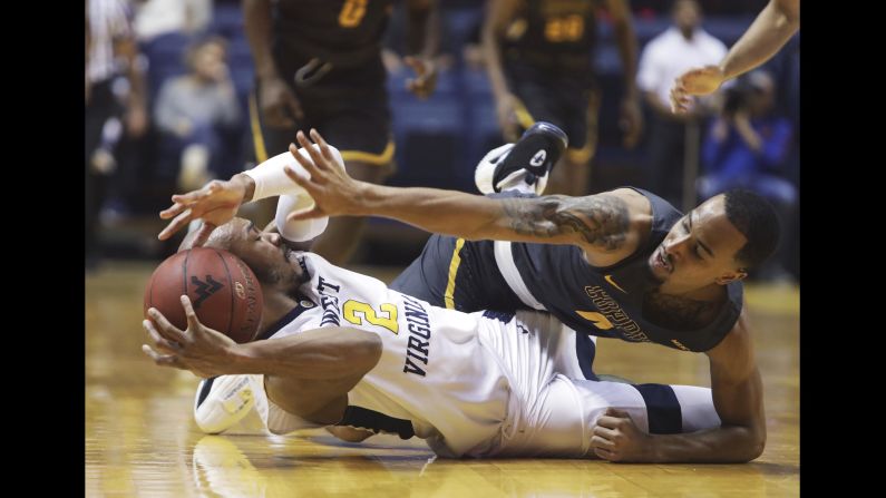 West Virginia guard Jevon Carter tries to make a pass after stealing the ball from Coppin State guard Tre Thomas during an NCAA basketball game in Morgantown, West Virginia, on Wednesday, December 20. West Virginia beat Coppin State 77-38.