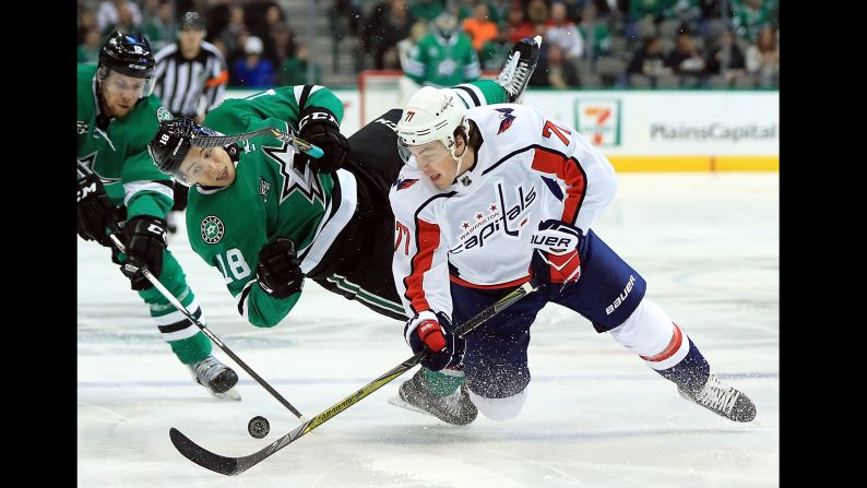 T.J. Oshie of Washington skates the puck against Dallas' Tyler Pitlick during an NHL game in Dallas, Texas, on Tuesday, December 19. Washington won 4-3.