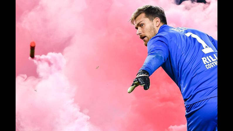 Benevento goalkeeper Vid Belec throws a flare that landed on the field during an Italian league soccer match against Genoa in Genoa, Italy, on Saturday, December 23. Genoa won 1-0.