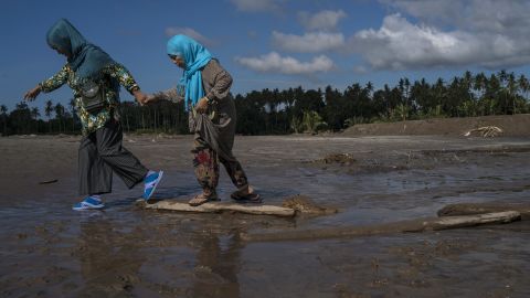 Residents walk through mud on  December 25 in Salvador, Lanao del Norte province, after Tembin swept the southern Philippines. Tembin is the nation's second deadly tropical storm this month.