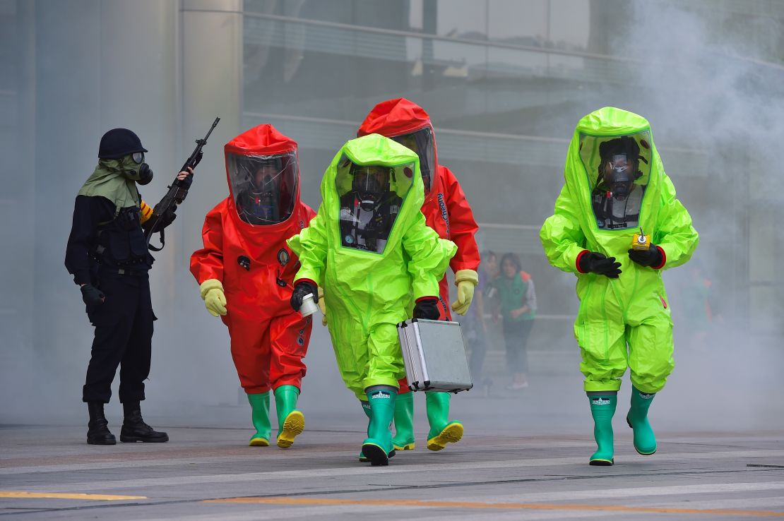 South Korean rescue workers wearing chemical protective suits participate in a disaster management exercise at the COEX shopping and exhibition center in Seoul on May 20, 2016.