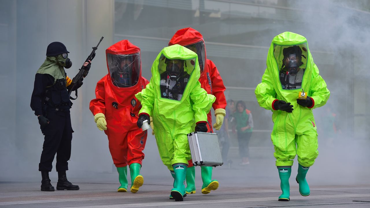 South Korean rescue workers wearing chemical protective suits participate in a disaster management exercise at the COEX shopping and exhibition center in Seoul on May 20, 2016.