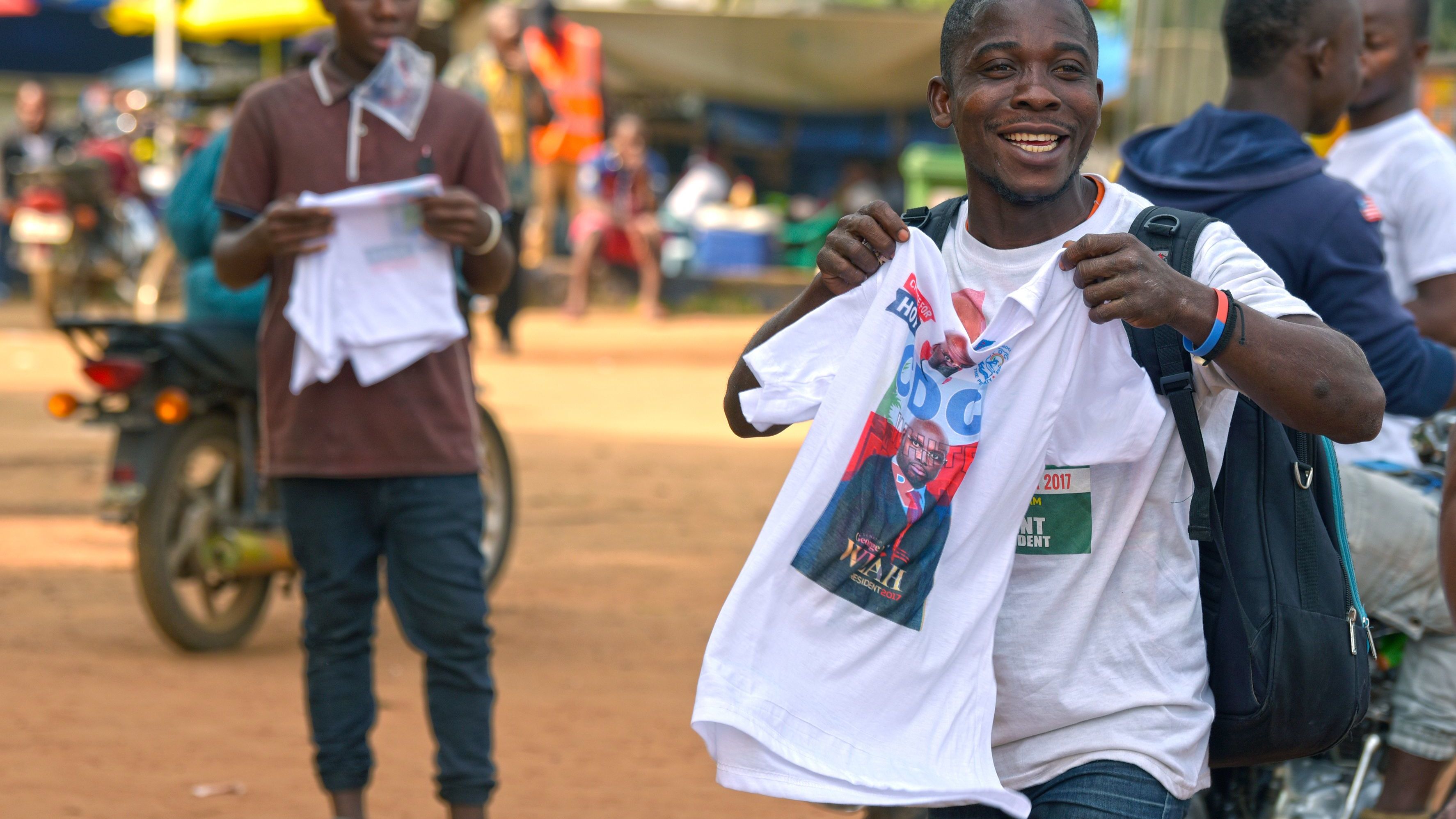 Supporters of candidate, ex-footballer George Weah react after they were given t-shirts at his Coalition for Democratic Change (CDC) party headquarters in Monrovia ahead of the run-off election.