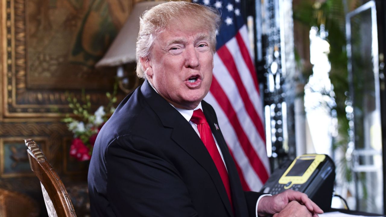 US President Donald J. Trump speaks to the media before participating in a video teleconference calls with military members on Christmas Eve in Palm Beach, Florida on December 24, 2017.  / AFP PHOTO / Nicholas KammNICHOLAS KAMM/AFP/Getty Images