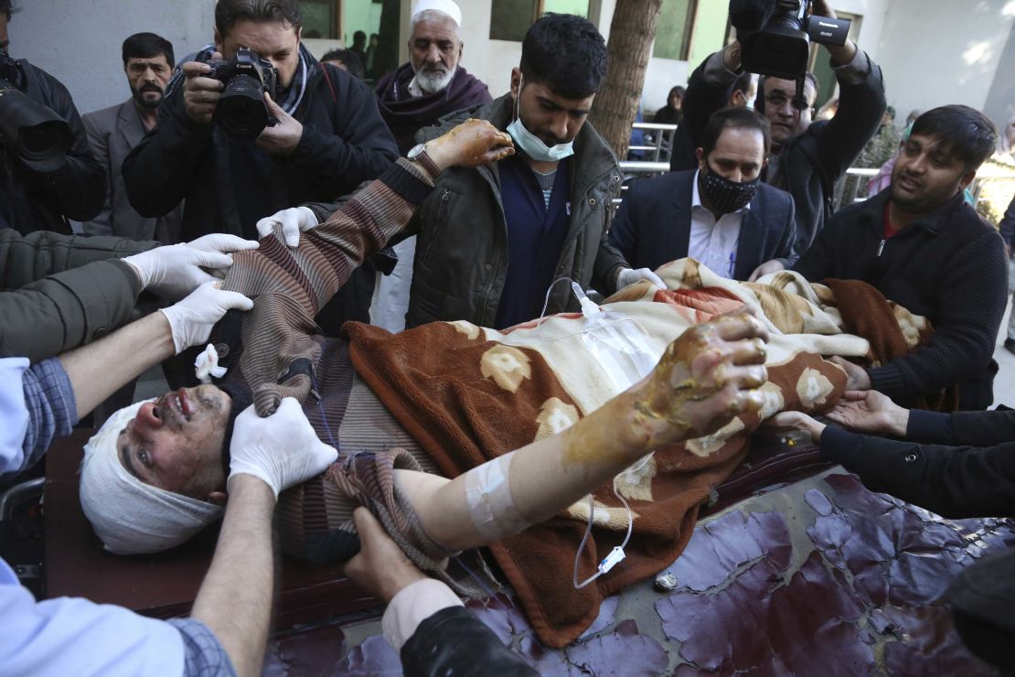 People carry an injured man to hospital after the suicide attack in Kabul on Thursday.