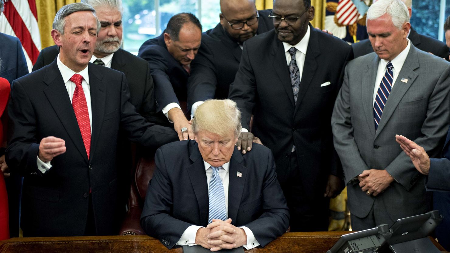 US President Trump bows his head during a prayer led by faith leaders and evangelical ministers after signing a proclamation declaring a day of prayer for victims of Hurricane Harvey in September. 