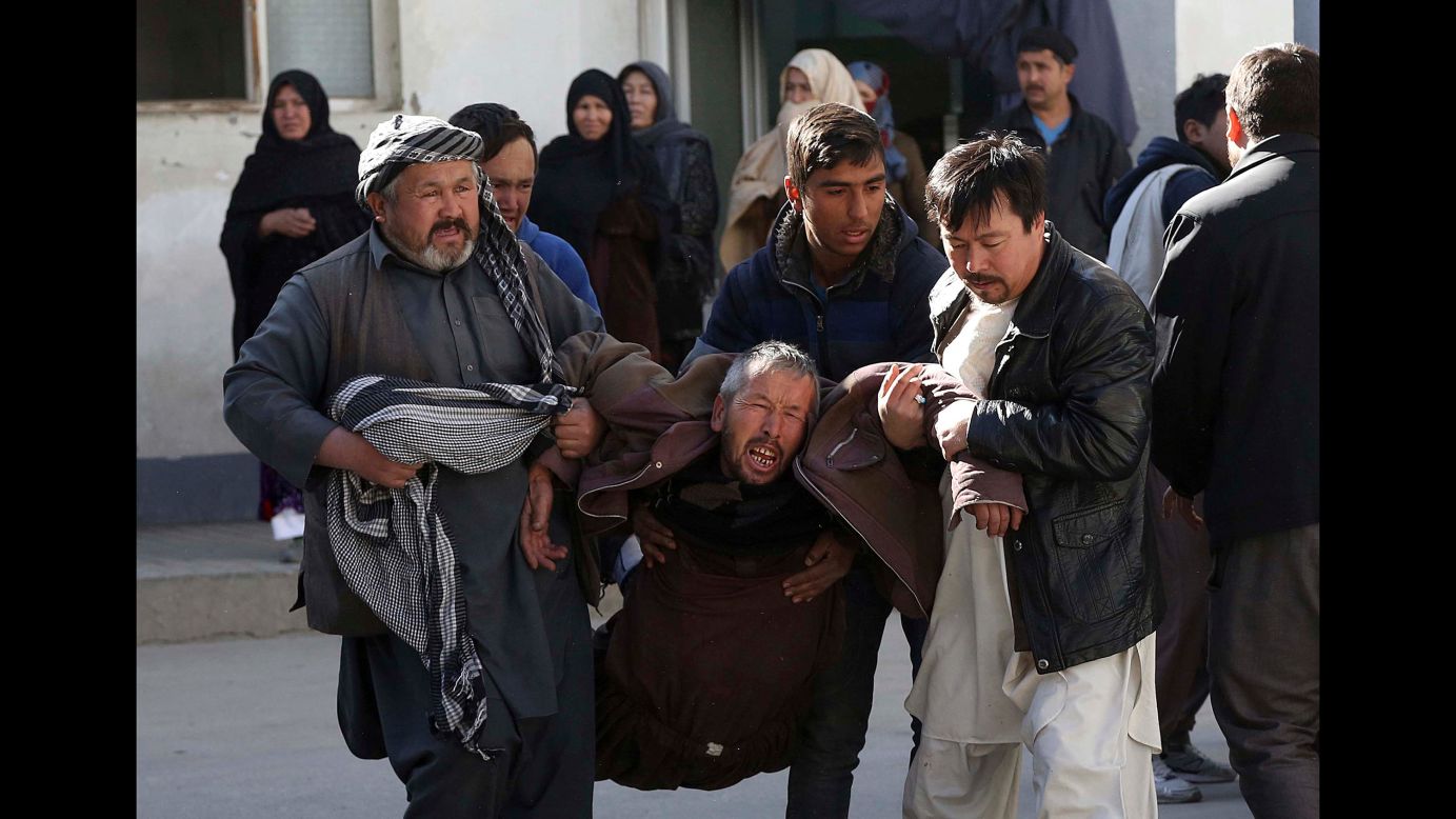 A man is carried away from a suicide attack in Kabul, Afghanistan, on December 28. A suicide bomber detonated explosives in the meeting room of a Shiite cultural center. The blast killed at least 40 people. 
