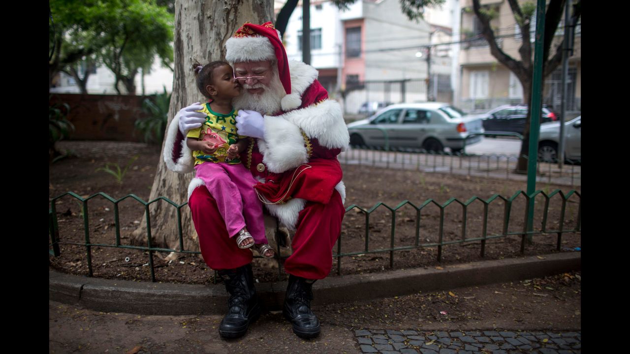 A man dressed as Santa Claus poses for pictures with a girl on December 26 in Rio de Janeiro.