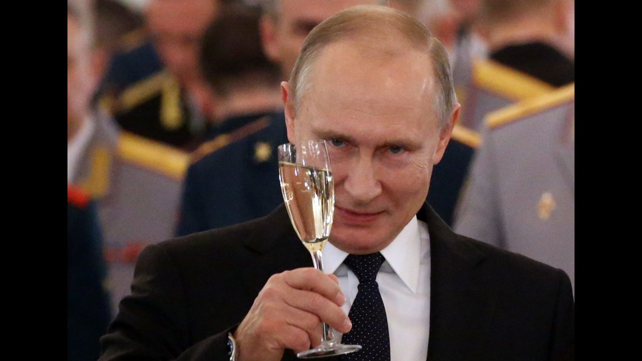 Russian President Vladimir Putin raises his glass for a toast on December 28 in Moscow, during a reception for military servicemen who took part in the Syrian campaign.