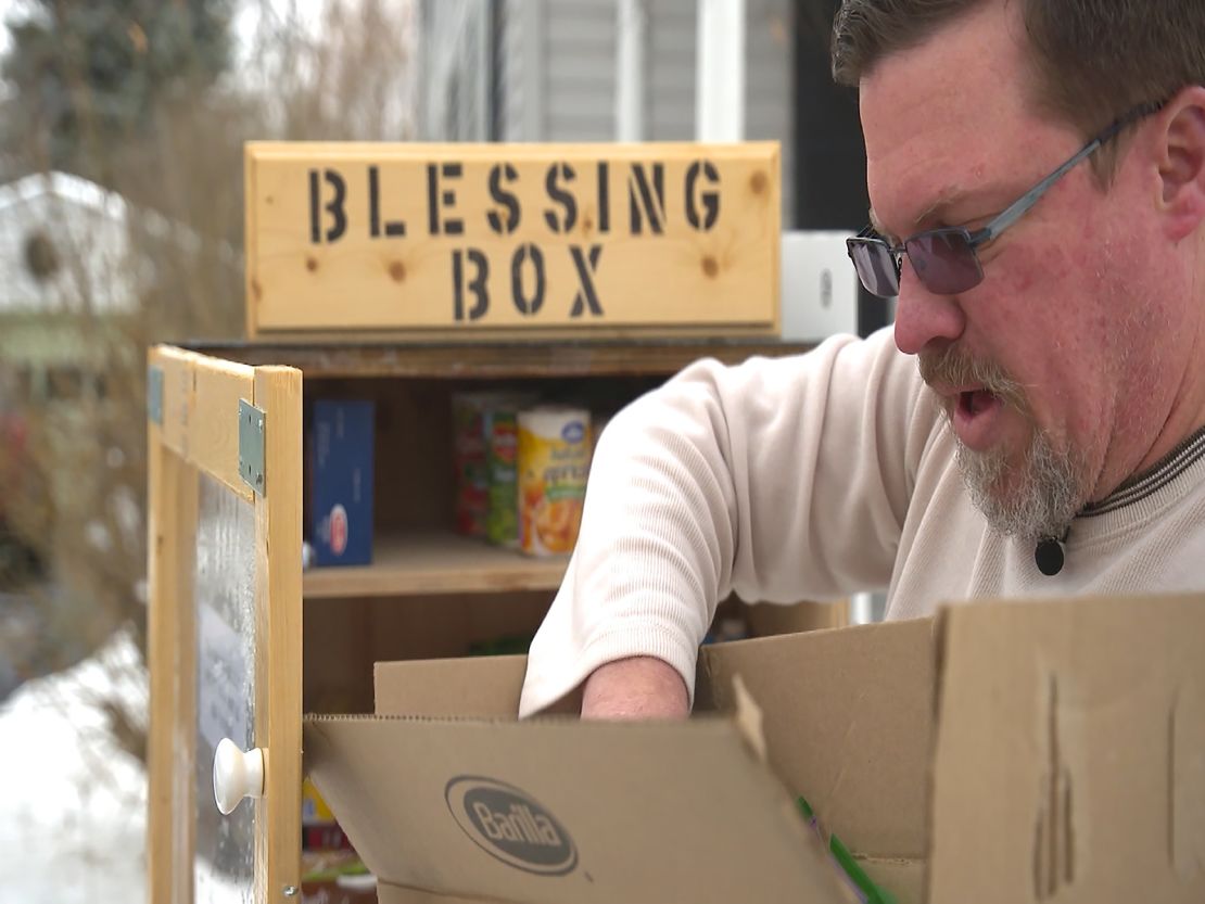 Chris Damm, a Watertown, New York resident, fills up the blessing box on his lawn with donated goods.