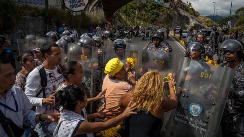 A group of protesters gather in front of members of the Bolivarian National Police in Caracas, Venezuela, on Thursday. 
