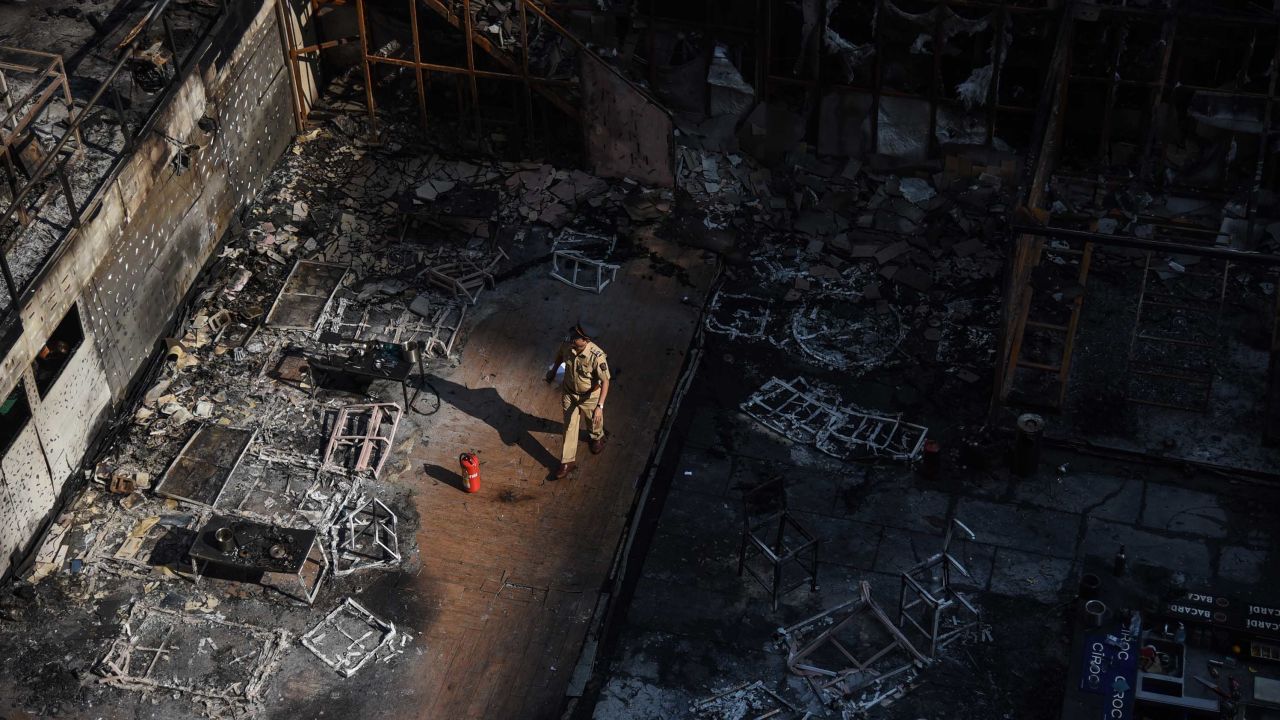 A policeman walks through the burned building on Friday morning.