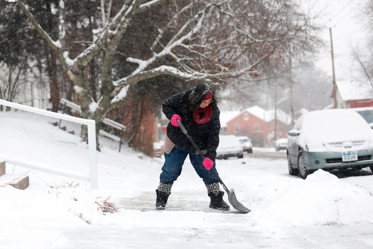 Samantha Dement-Graham shovels her neighbor's sidewalk in Dubuque, Iowa, on Friday, December 29.