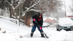 Samantha Dement-Graham shovels her neighbor's sidewalk on University Avenue in Dubuque, Iowa, on Dec. 29, 2017.  Cold arctic air dipping further south than usual prompted Omaha, Nebraska, officials to cancel a New Year's Eve fireworks show as a three-day deep freeze chills celebrations in Iowa and Nebraska. The National Weather Service is warning of hazardous weather conditions as a deep freeze sets in with expected temperatures in some locations dipping near records not seen in more than 130 years. (Eileen Meslar/Telegraph Herald via AP)