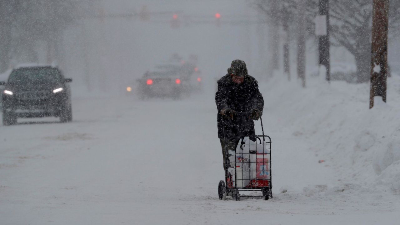 A man walks with his groceries in a cart, Friday, Dec. 29, 2017, in Erie, Pa. The cold weather pattern was expected to continue through the holiday weekend and likely longer, according to the National Weather Service, prolonging a stretch of brutal weather blamed for several deaths, crashes and fires. (AP Photo/Tony Dejak)