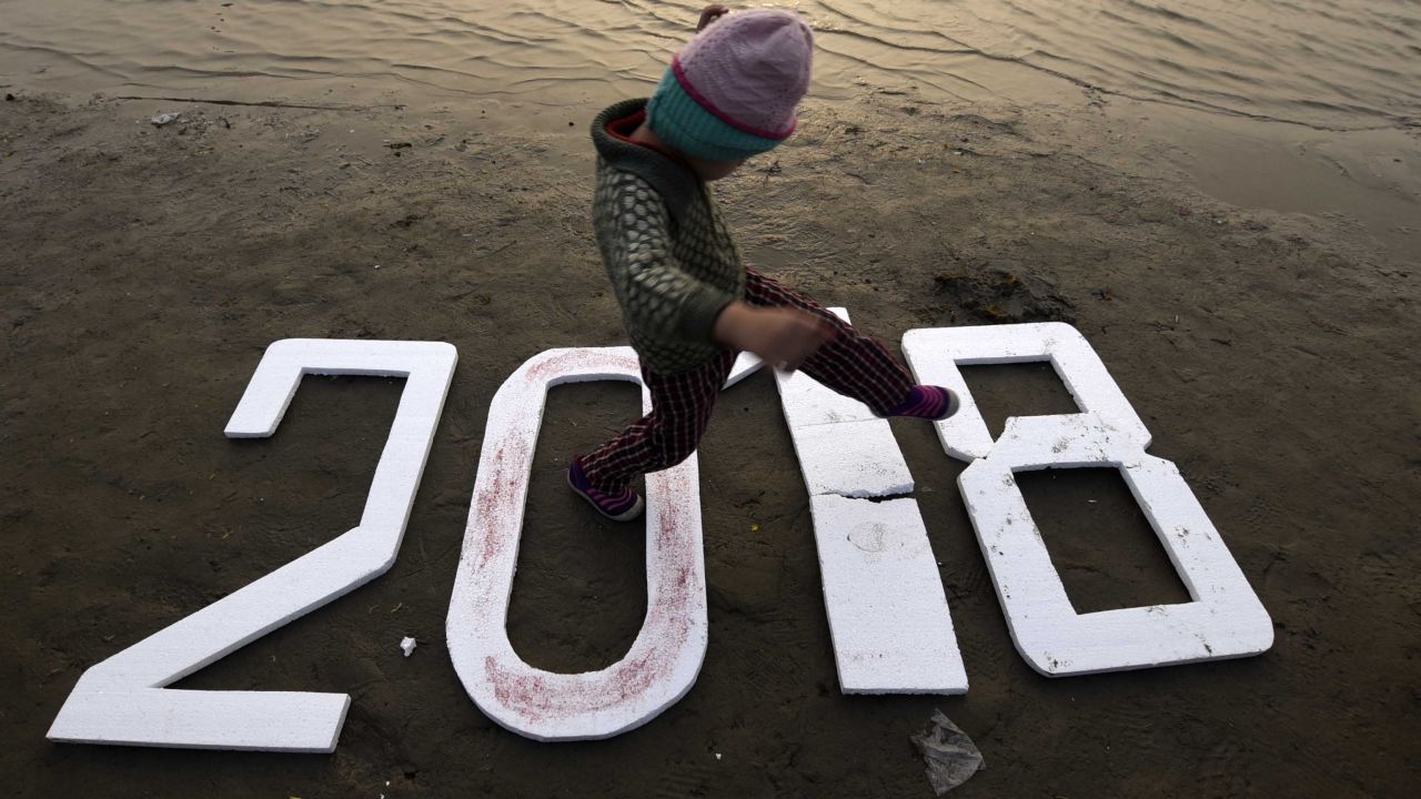 A child walks on numbers reading "2018" in Allahabad, India.