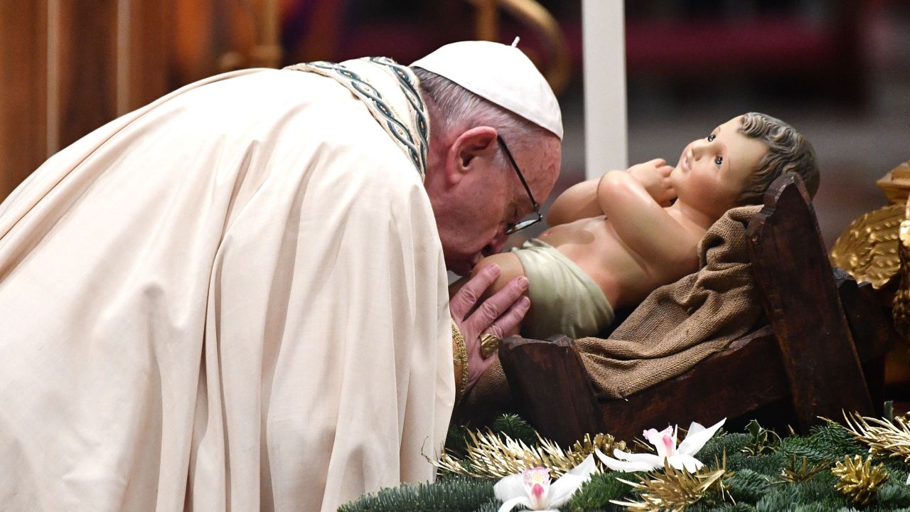 Pope Francis kisses the Christ Child upon his arrival to preside over the Te Deum prayer in St, Peter's Basilica at the Vatican.