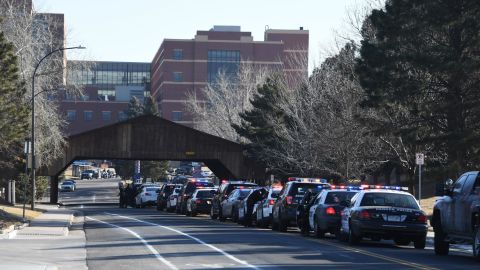Officers from various police agencies line up in front of a Littleton hospital as they wait for a procession for a fallen deputy.