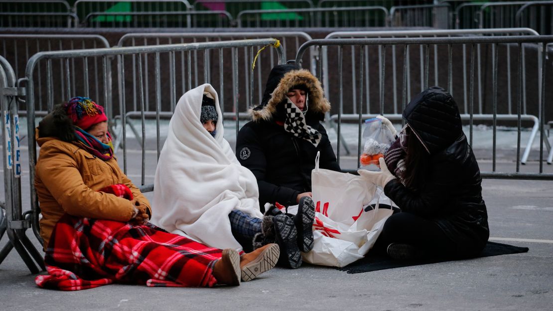 Revellers stay warm in Times Square early Sunday morning as they prepare for New Year's Eve celebrations.