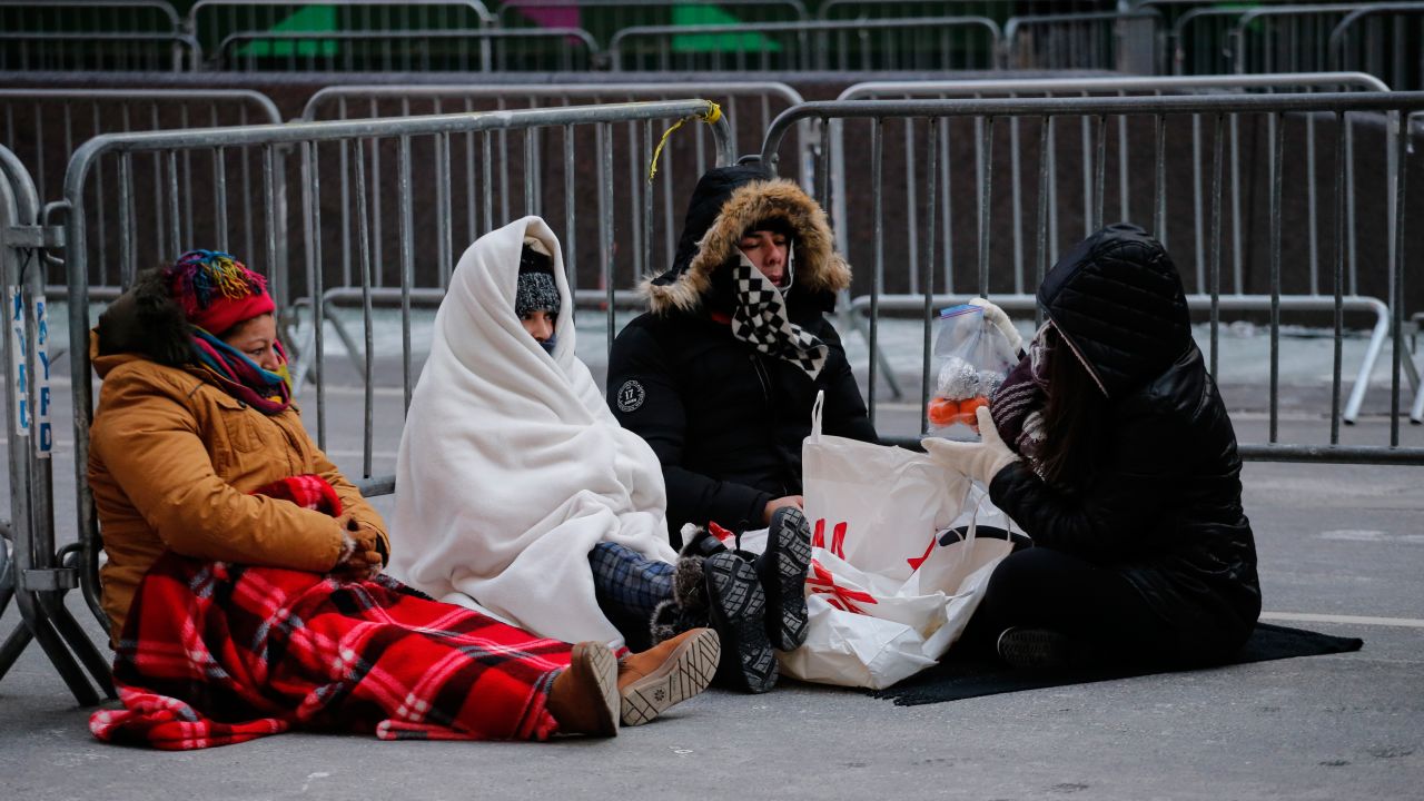 Revellers stay warm in Times Square early Sunday morning as they prepare for New Year's Eve celebrations.