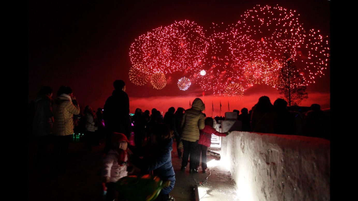 People in Kim Il Sung Square watch fireworks light the sky above the Taedong River in Pyongyang, North Korea.