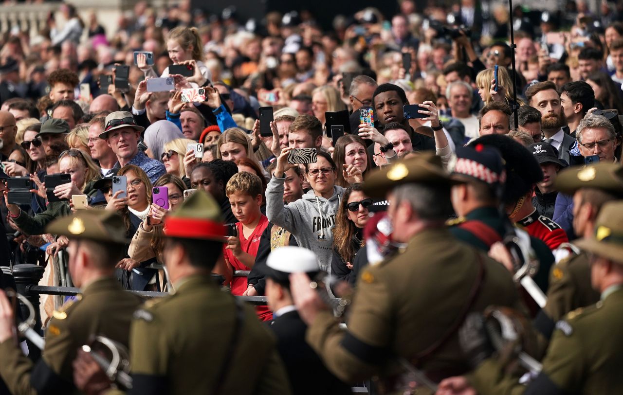 Mourners pay their respects as the procession passes by.