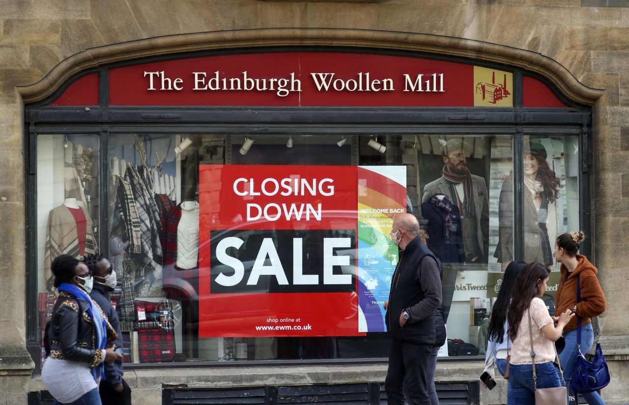 People walk by The Edinburgh Woollen Mill shop in Oxford, England, on October 19.