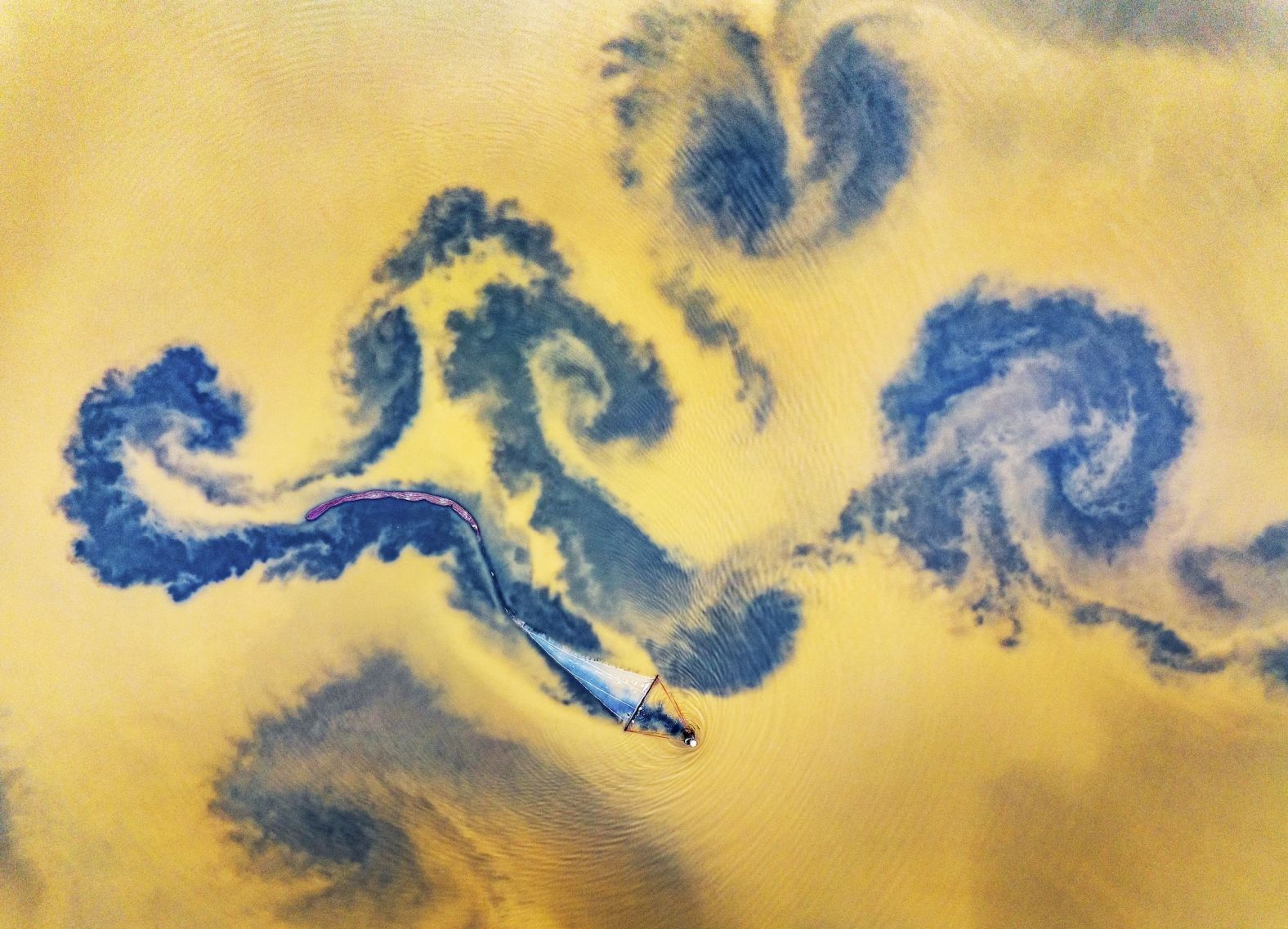 This aerial photo, taken Sunday, November 10, shows a fisherman harvesting brine shrimp in a salt lake in Yuncheng, China.