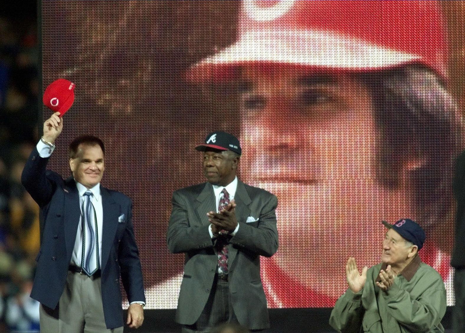 Rose tips his cap to fans in Atlanta after he was named to baseball's All-Century Team in 1999. With him, from left, are Hank Aaron and Ted Williams.