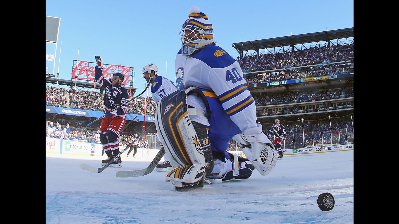 New York Rangers forward Paul Carey, left, celebrates after scoring on Buffalo goalie Robin Lehner on Monday, January 1. The Rangers triumphed 3-2 in the NHL Winter Classic, which was played at Citi Field, home of the New York Mets baseball team.