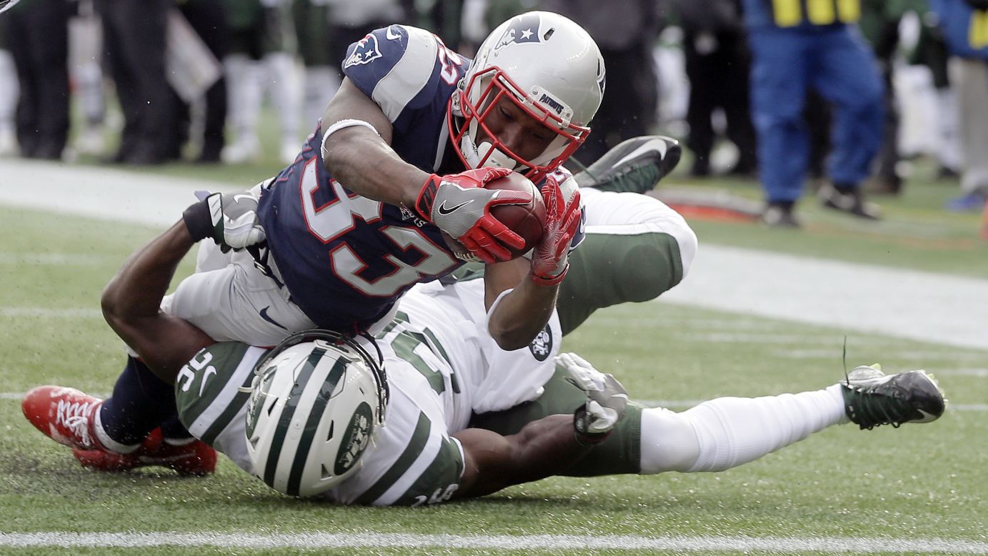 New England running back Dion Lewis dives over New York Jets safety Marcus Maye to score a touchdown on Sunday, December 31. New England won 26-6 to clinch home-field advantage in the AFC playoffs.