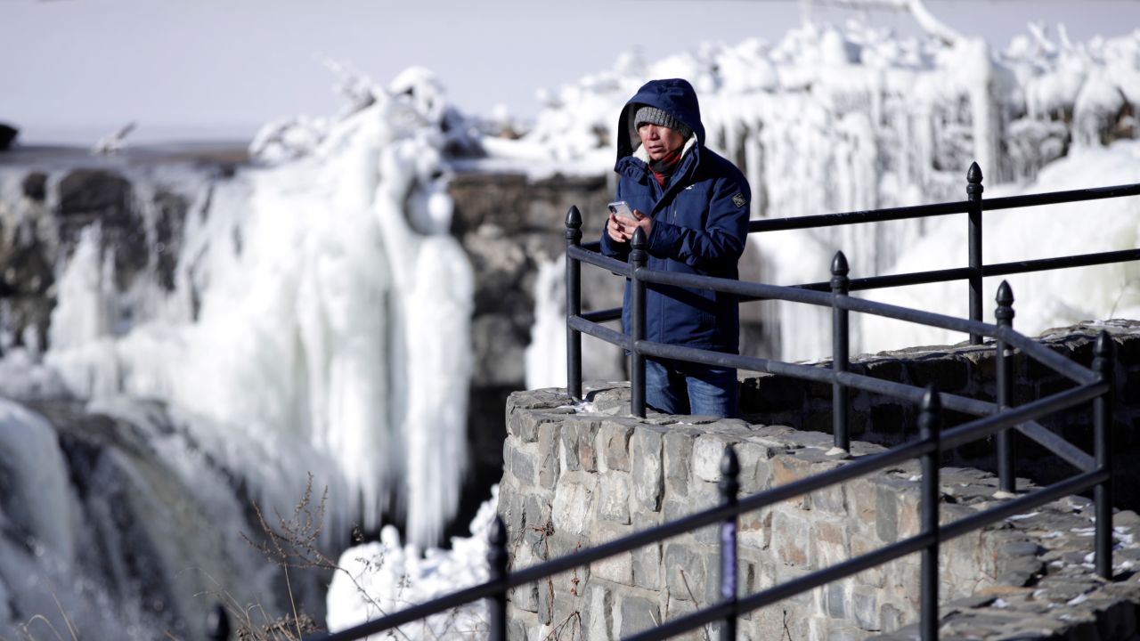 Obdulio Arenas looks over the partially frozen falls at the Paterson Great Falls National Historical Park in New Jersey on Tuesday. 