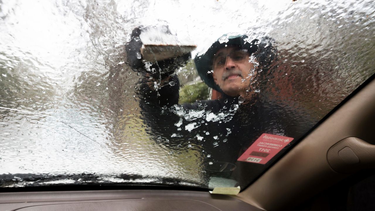 Omar Elkhalidi scrapes ice off his windshield in Savannah, Georgia, on January 3. Few motorists ventured out in freezing rain that coated bridges and ramps with ice, forcing police to close roads and highways.