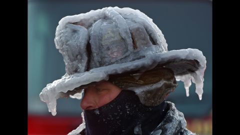 Firefighter Bobby Lehman, with his helmet and gear caked in ice, tries to thaw out after battling a fire in Nahant, Masschusetts, on Monday, January 1.