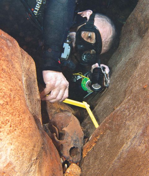 The team is led by underwater archaeologist Guillermo de Anda. He is pictured measuring a bear skull that dates from the ice age, found in a cenote.<br />