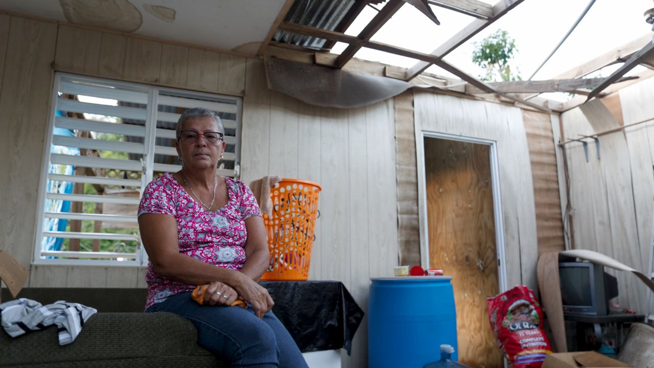 Carmen Torres lives with her sister across the street from her tattered home.