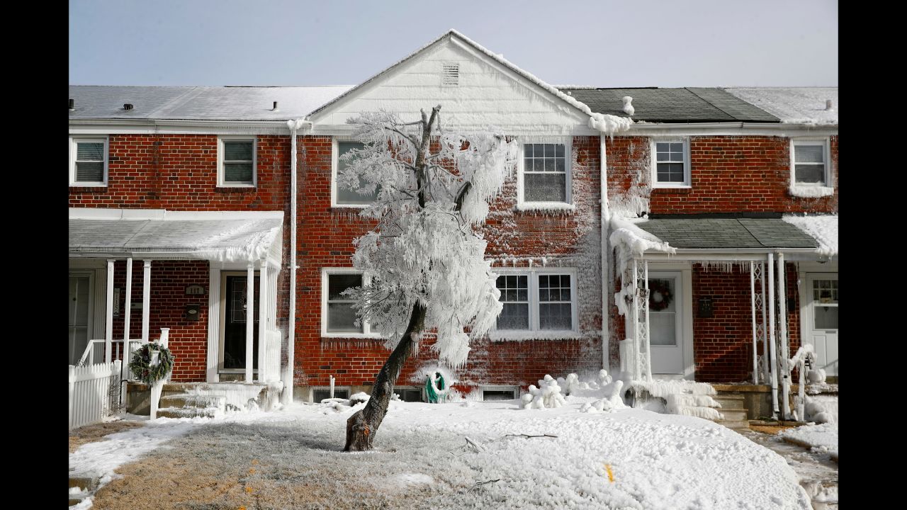 A tree and rowhouse are partially covered by ice after a water main break in Catonsville, Maryland, on January 3.