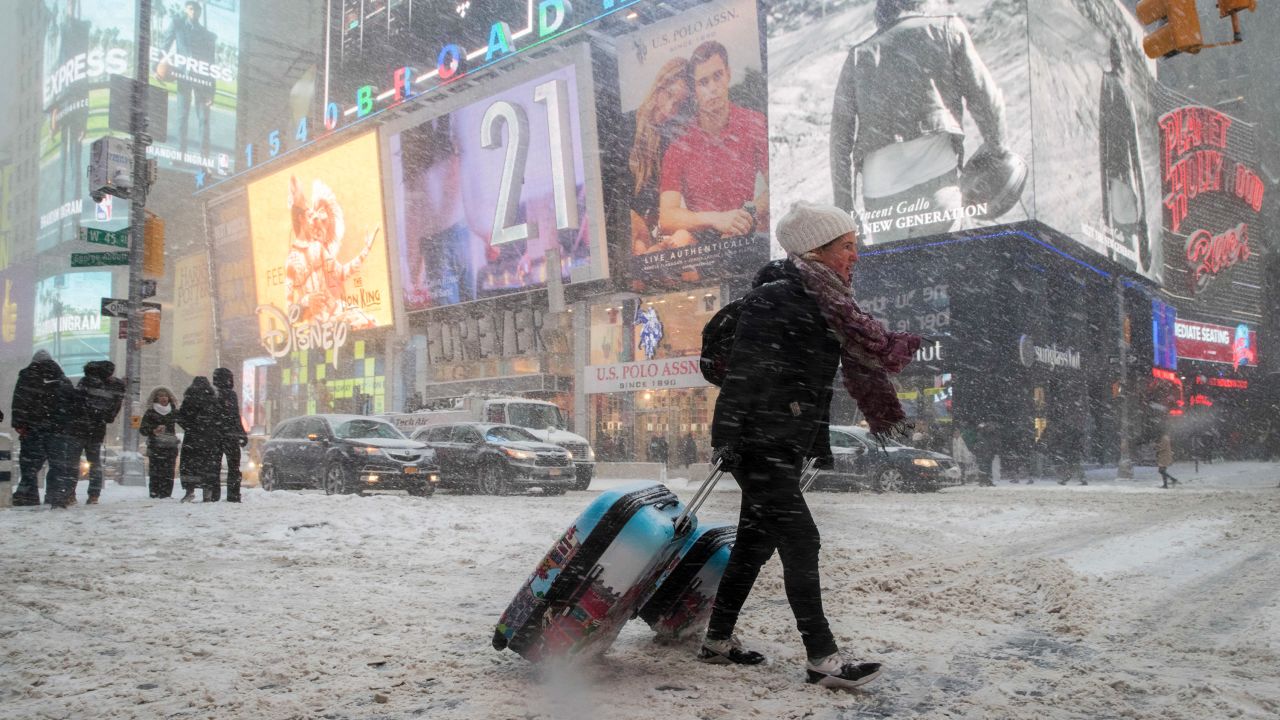 Rebecca Hollis drags her suitcases through New York's Times Square on January 4.