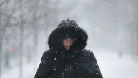 A man walks through the streets of Boston as snow begins on January 4. The brutal cold comes after a "bomb cyclone" dumped more than a foot of snow across eight states.